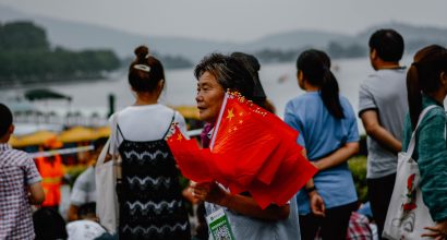 Elderly woman holding chinese flags